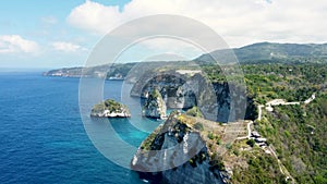 Fly around cliff and rocks over ocean along coast