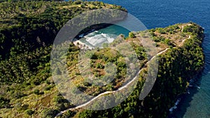 Fly around cliff and rocks over ocean along coast