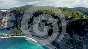 Fly around cliff and rocks over ocean along coast