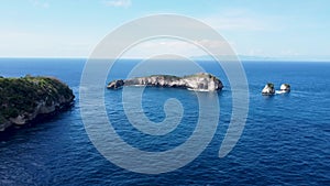 Fly around cliff and rocks over ocean along coast