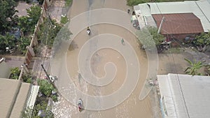 Fly backwards over motorcycles vehicles driving through a flooded street