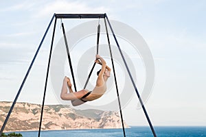 Fly-dance yoga poses in a hammock with mountains view. Harmony with nature