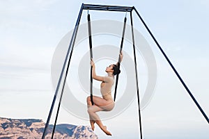 Fly-dance yoga poses in a hammock with mountains view. Harmony with nature