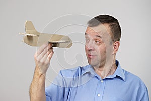 Fly fear. Man holding airplane in hand