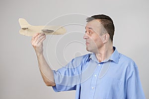 Fly fear. Man holding airplane in hand