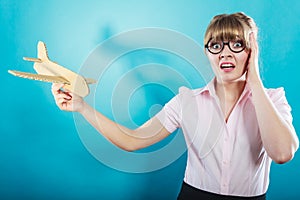 Fly fear. Woman holding airplane in hand.