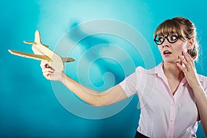 Fly fear. Woman holding airplane in hand.