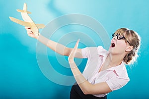 Fly fear. Woman holding airplane in hand.