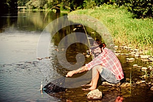 fly fish hobby of man. Hipster in checkered shirt. hipster fishing with spoon-bait. big game fishing. relax on nature