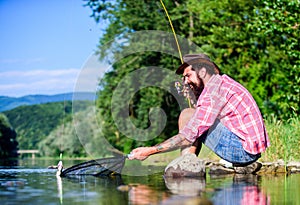 Fly fish hobby. Summer activity. successful fisherman in lake water. big game fishing. relax on nature. mature bearded