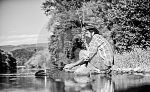 fly fish hobby. Summer activity. successful fisherman in lake water. mature bearded man with fish on rod. big game