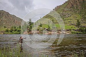 Fly fisherman casting a fly on a river in Mongolia during the summer, Moron, Mongolia