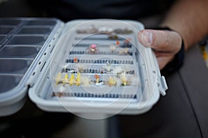 Fly fisherman checking his tackle box for flies