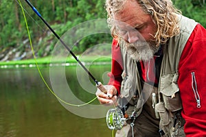 Fly fishing angler makes cast while standing in water