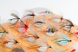 Fly fishing fly on the rod on white background. Reel and vintage
