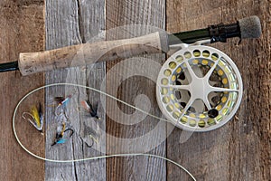 Fly fishing gear and tackle on weathered wood.