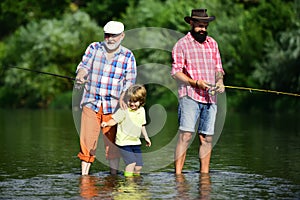 Fly Fishing. Little boy fly fishing in river with his father and grandfather.