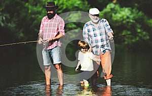 Fly Fishing. Little boy fly fishing in river with his father and grandfather.