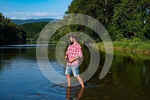 Fly fishing in the pristine wilderness of America. Portrait of cheerful man fishing.