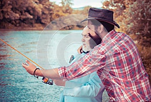 Fly fishing in the pristine wilderness of Canada. Portrait of cheerful two bearded men fishing. Fly fisherman using fly
