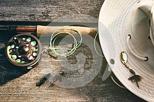 Fly fishing rod with hat on wood