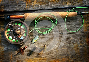 Fly fishing rod with polaroids pictures on wood