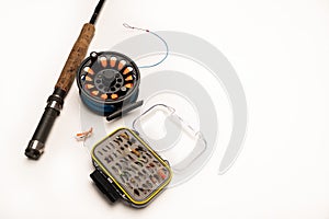 Fly fishing rod, reel, and flies on a white background