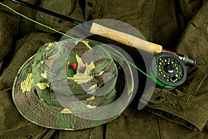 Fly Fishing Rod and Reel with Line on an Outdoor Coat with Fishing Hat and Trout Flies