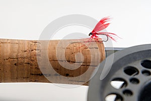 Fly fishing fly on the rod on white background. Reel and vintage