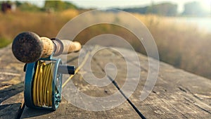 Fly fishing rod with on wood background. Autumn sunny day. Autumn sunny day