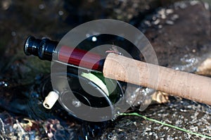 Fly fishing vintage reel and rod in water