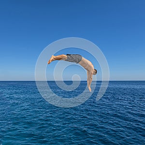 Fly after jump. Man jumping in blue sea water for dive. Summer fun lifestyle