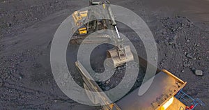 Fly over around, excavator loads coal into dump truck