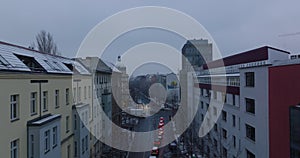 Fly over queue of cars stopping at traffic lights on road intersection. Winter city at dusk. Berlin, Germany