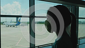 Fly passenger little girl awaiting boarding looks in window on airplane