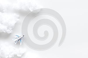 Fly by plane concept. Airplane model and clouds on white background top view frame copy space