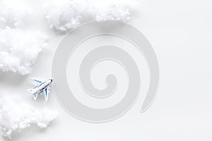 Fly by plane concept. Airplane model and clouds on white background top view frame copy space