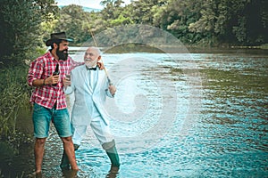 Fly rod and reel with a brown trout from a stream. Brown trout fish. Grandfather and boy fishing together. Fly fishing