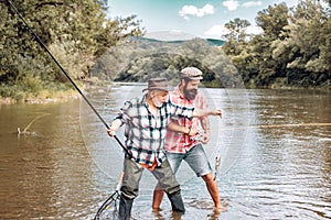 Fly rod and reel with a brown trout from a stream. Man fishing. Fly fisherman using fly fishing rod in beautiful river