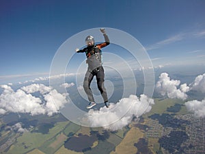 Extreme. Man with parachute flies in the blue sky. Free fall. Skydiving sports.