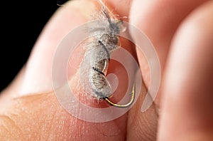 Fly to catch fish in a hand on a black background