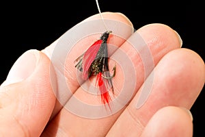 Fly to catch fish in a hand on a black background