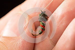 Fly to catch fish in a hand on a black background