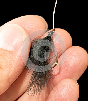 Fly to catch fish in a hand on a black background