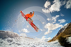 Fly young caucasian man jumping from a springboard on skis