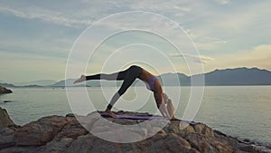 Flycam view girl stands in yoga position against seascape