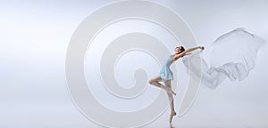 Flyer with young girl, aspiring ballerina in blue dress and pointes dancing with cloth  on gray background. Art
