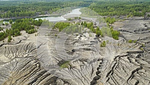 Flying above the abandoned clay quarry with canyons and cracks