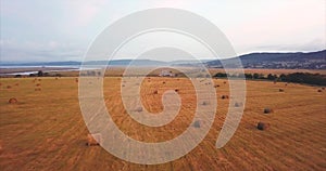 Flying above and aerial view of a field with hay stacks. Rural scene. Russia