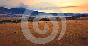 Flying above and aerial view of a field with hay stacks. Rural scene. Russia